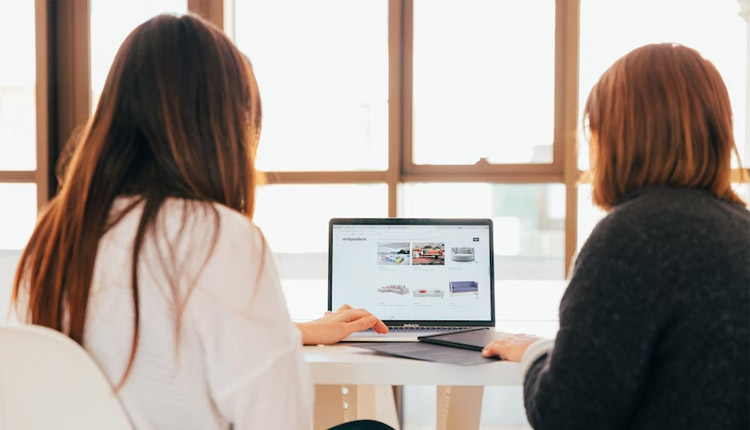 deux femmes regardant un site web